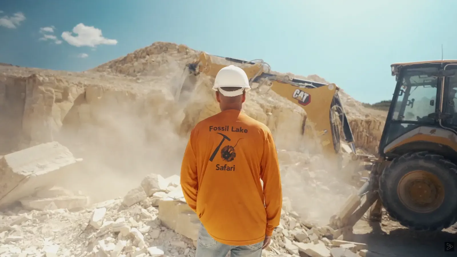 Excavator opening a limestone deposit at Fossil Lake Safari during promotional video production