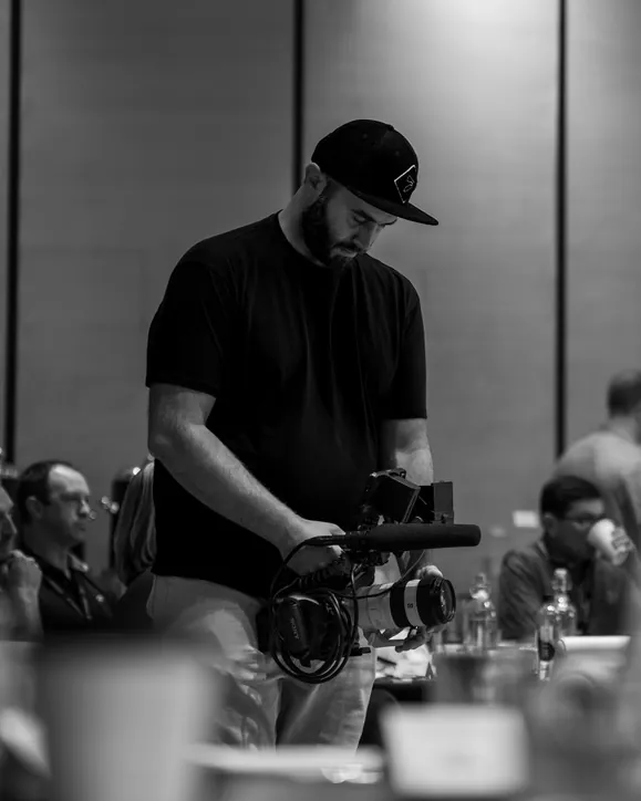 Event videographer Andrew Eckhoff setting up his camera at a conference, Eagle Wing Productions video production for Ogden businesses