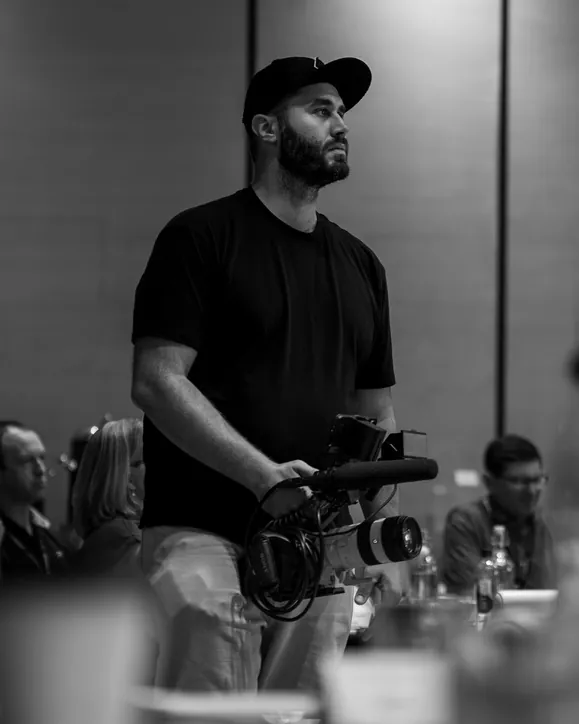 Andrew Eckhoff filming a corporate event with a handheld cinema camera, Eagle Wing Productions video production for Provo businesses