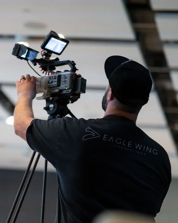 Andrew Eckhoff filming on a tripod-mounted cinema camera, Eagle Wing Productions video production for Sandy businesses